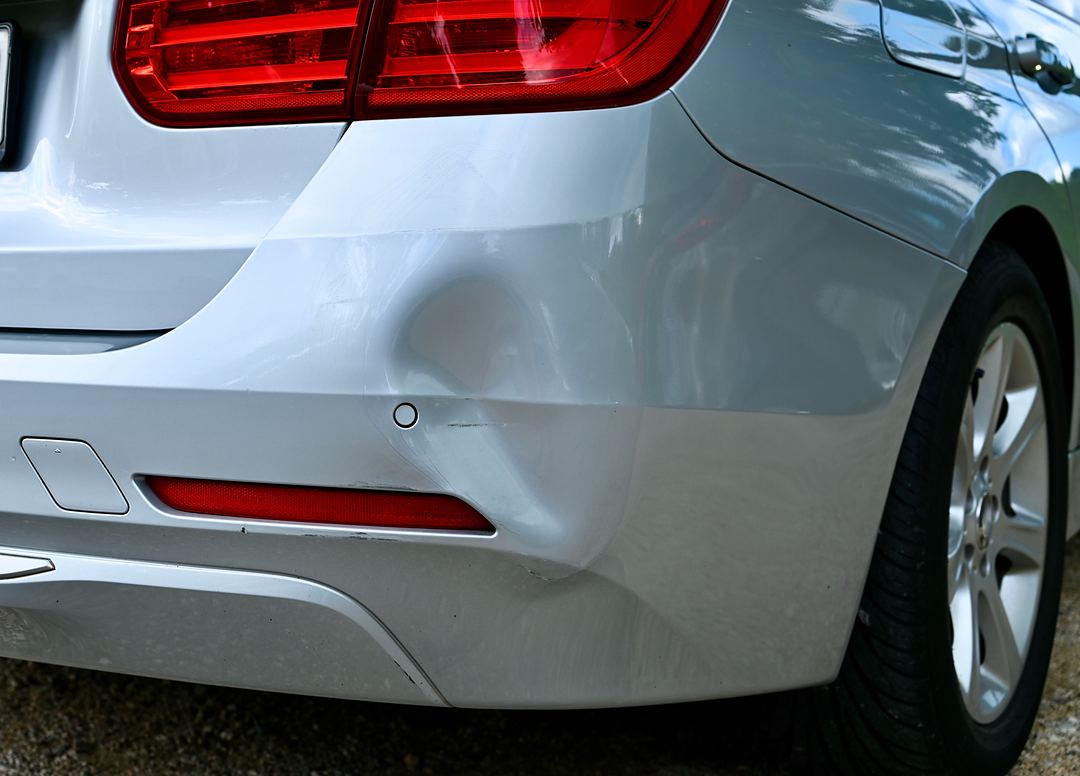 Delle im hinteren Stoßfänger eines silbernen Autos